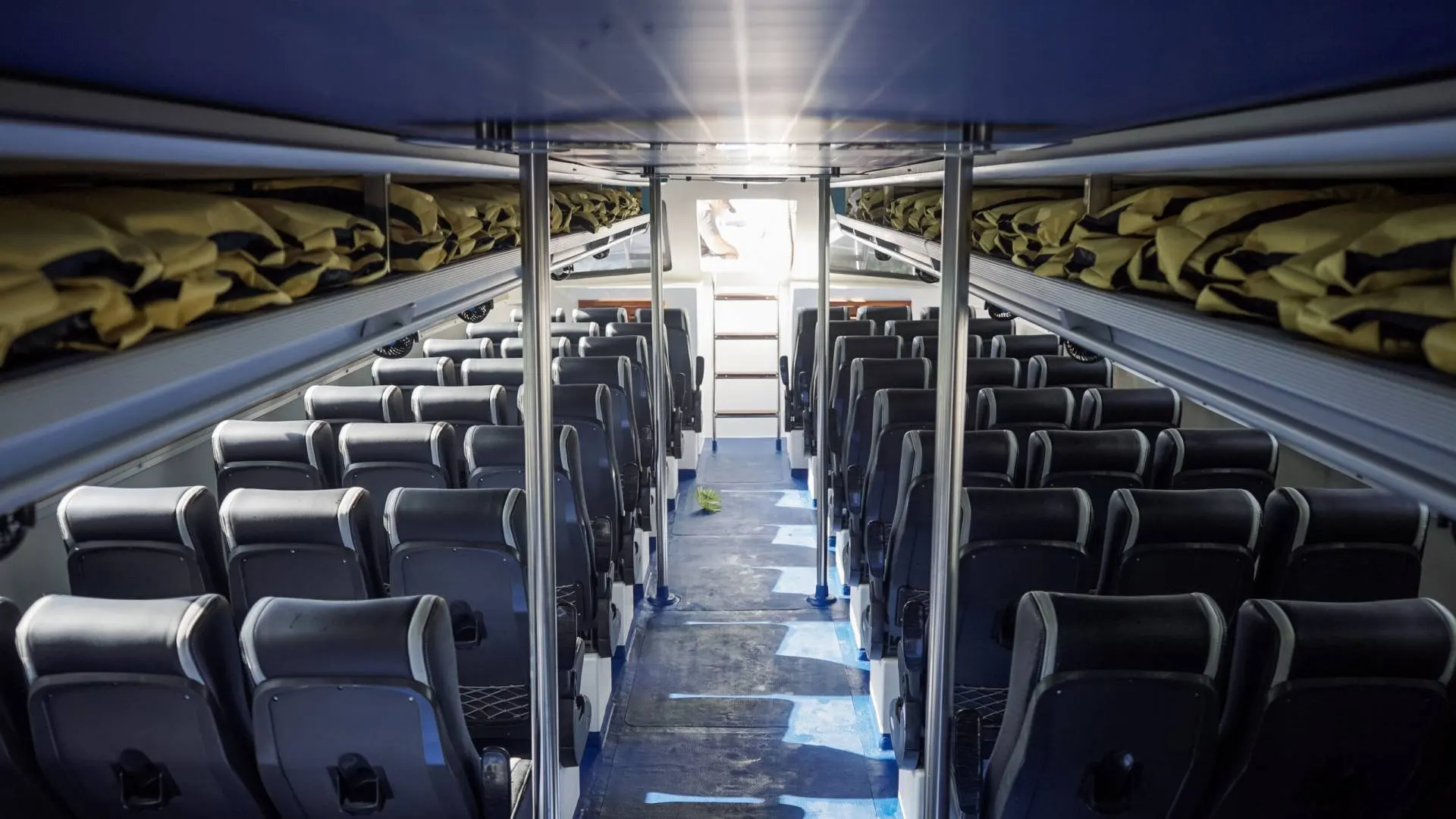 Interior of Arthamas Express fast boat with comfortable padded passenger seats rear view cabin