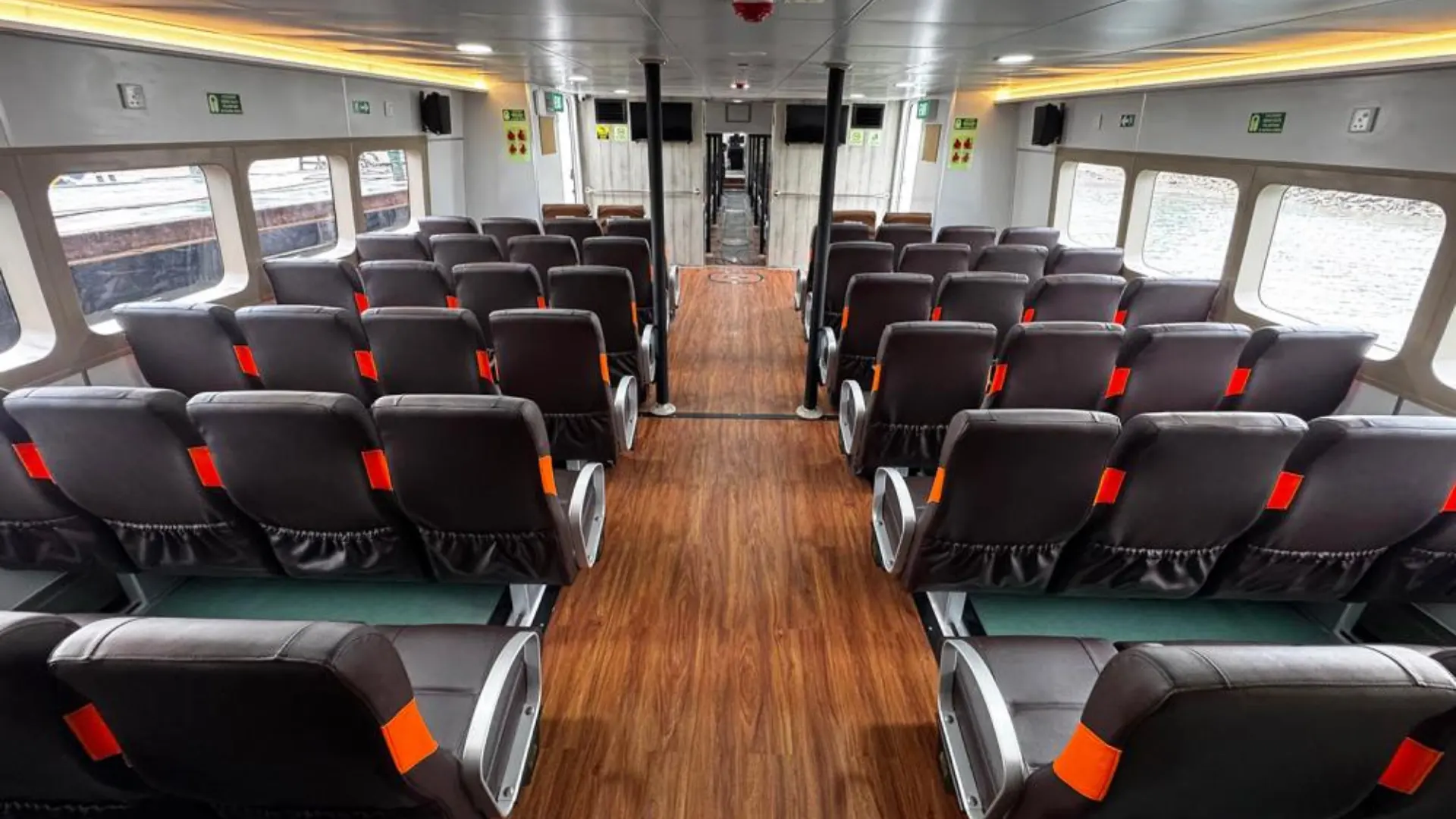 Interior of Dcamel ALX Fast Ferry with comfortable padded seats, air conditioning, and TV rear cabin view