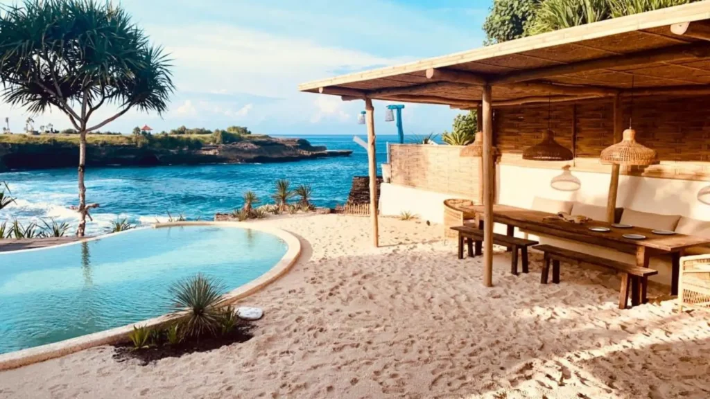 Sunset view at Sandy Bay Beach Club Nusa Lembongan featuring poolside lounge and stunning ocean scenery